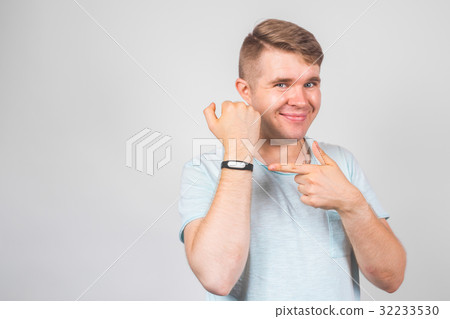 Cheerful young man standing and pointing on Cheerful young man standing and pointing on 32233530