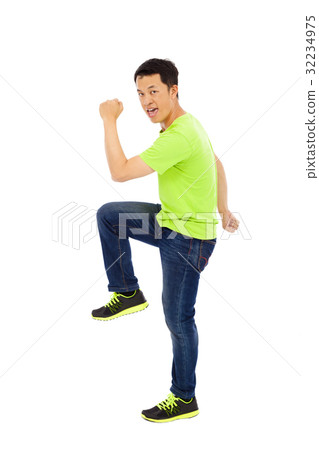 Young happy man raise hand and leg Young happy man raise hand and leg 32234975