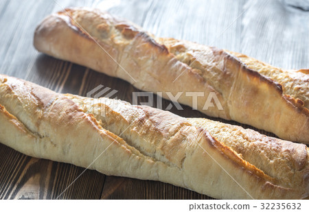 Two baguettes on the wooden background Two baguettes on the wooden background 32235632