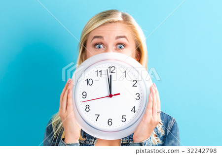 Woman holding clock showing nearly 12 Woman holding clock showing nearly 12 32242798