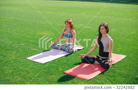 Group of people meditating in lotus pose on the 32242882
