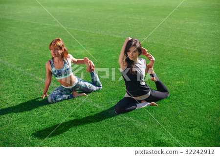 Two young yoga female doing yogatic exericise at 32242912