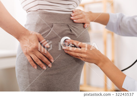 Professional doctor checking up a pregnant woman 32243537