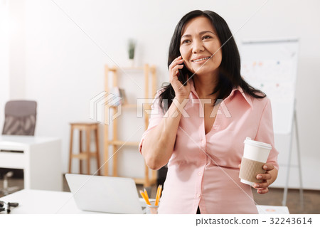 Nice pregnant woman talking on phone in the office Nice pregnant woman talking on phone in the office 32243614