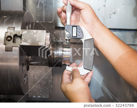 operator machining mold part by CNC machine 32243789