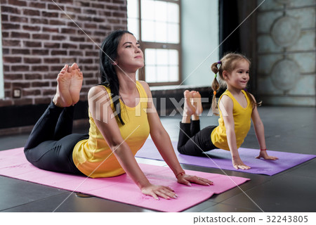 Two female gymnasts of different age doing 32243805