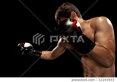 Male boxer boxing in punching bag with dramatic Male boxer boxing in punching bag with dramatic 32243933
