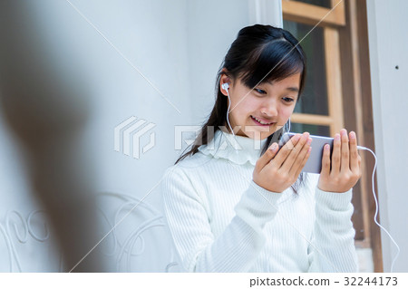 Girls using smart girls playing earphones female junior high school student house studios house 32244173