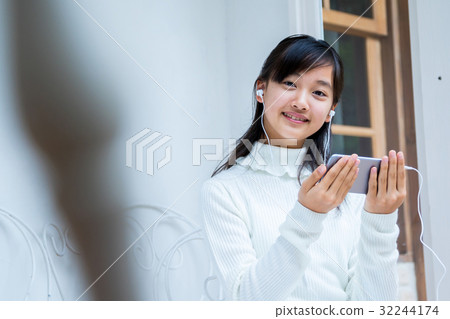 Girls using smart girls playing earphones female junior high school student house studios house 32244174