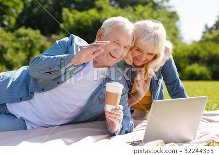 Happy elderly people looking at screen of laptop Happy elderly people looking at screen of laptop 32244335