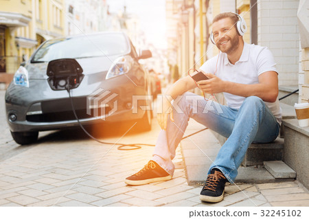 Upbeat man listening to the music on the steps 32245102