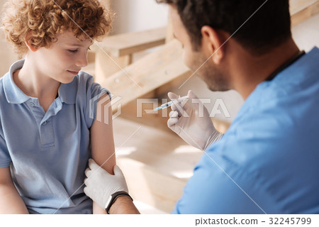 Worried boy looking at little syringe 32245799