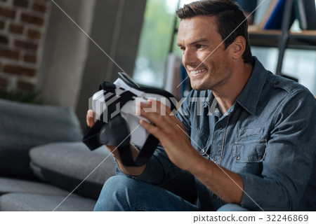 Lively joyful man holding a VR gear 32246869