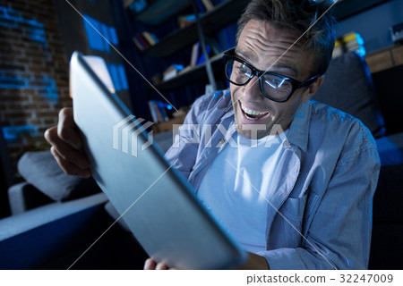 Overly emotional man crazy about the new game 32247009