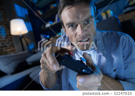 Expressive young guy being emotional while playing 32247010