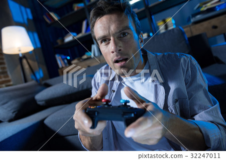 Focused charismatic man obsessed with video games 32247011
