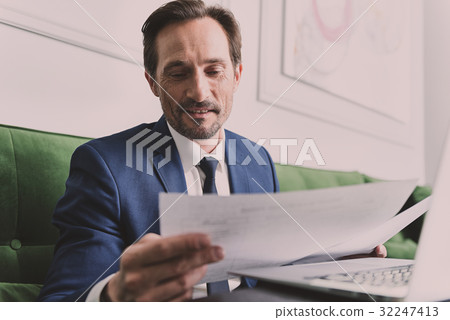 Smart businessman working with papers and laptop 32247413