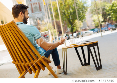 Savvy productive guy sitting on a terrace with 32247850