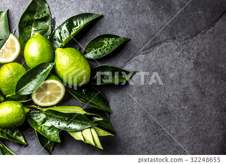 Green lemon Lime with fresh leaves on slate 32248655