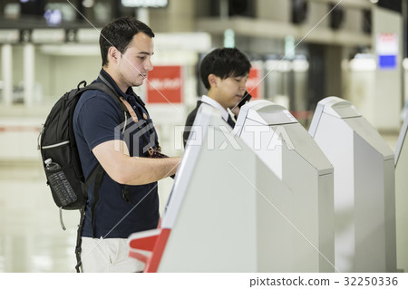 Foreigner backpacker using automatic check-in machine Foreigner backpacker using automatic check-in machine 32250336