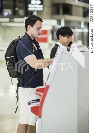 Foreigner backpacker using automatic check-in machine Foreigner backpacker using automatic check-in machine 32250337
