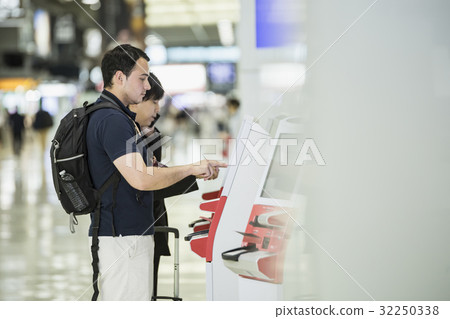 Foreigner backpacker using automatic check-in machine Foreigner backpacker using automatic check-in machine 32250338