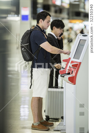 Foreigner backpacker using automatic check-in machine Foreigner backpacker using automatic check-in machine 32250340