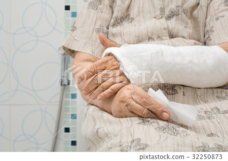 Senior woman with broken arm using the toilet Senior woman with broken arm using the toilet 32250873