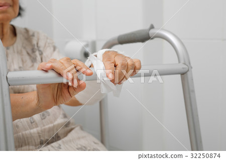 Senior woman broken arm using toilet with walker. Senior woman broken arm using toilet with walker. 32250874