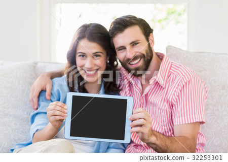 Portrait of couple showing digital tablet Portrait of couple showing digital tablet 32253301