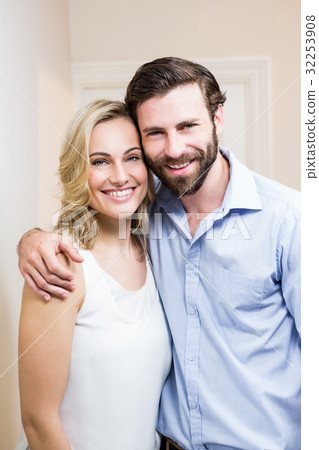 Happy couple standing with arm around Happy couple standing with arm around 32253908