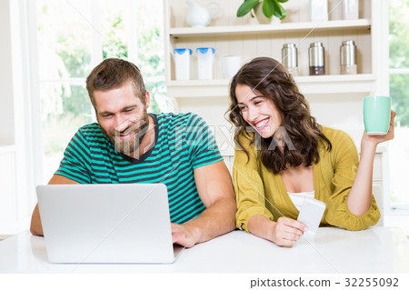 Couple using laptop while having coffee Couple using laptop while having coffee 32255092