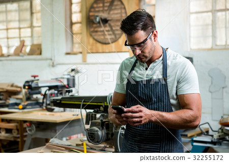 Carpenter using phone Carpenter using phone 32255172