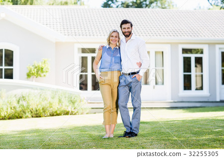 Portrait of happy couple standing with arm around Portrait of happy couple standing with arm around 32255305