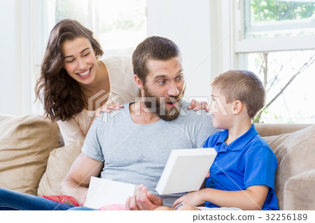 Father opening gift box in living room 32256189