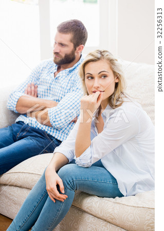 Young couple ignoring each other in living room 32256313