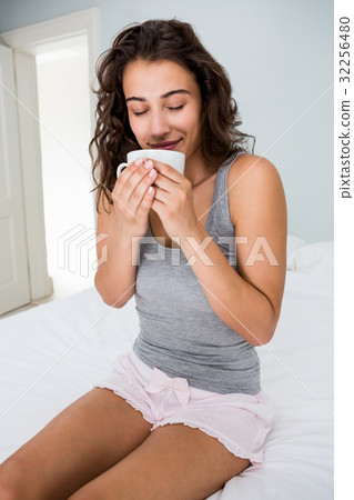 Woman having coffee on bed Woman having coffee on bed 32256480