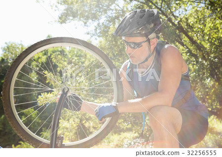 Senior man is touching his bike 32256555