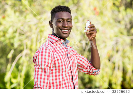 Happy man posing and holding an object Happy man posing and holding an object 32256623