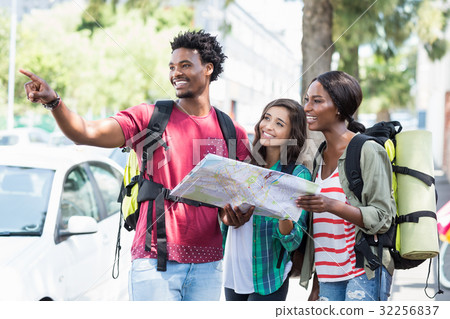 Friends holding map and pointing Friends holding map and pointing 32256837