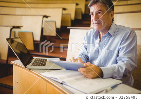 Thoughtful professor using digital tablet 32258493