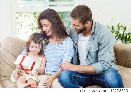 Daughter receiving surprise a gift from her parents 32258863