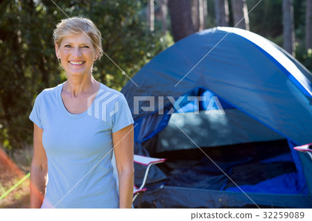 Senior woman standing in front of a tent 32259089