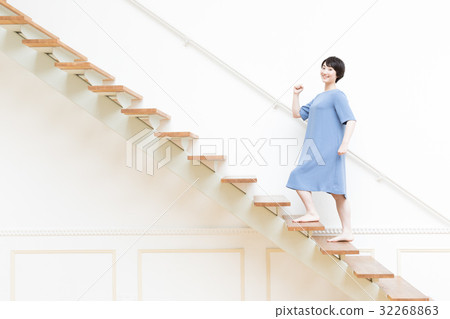 A young woman standing up the stairs 32268863
