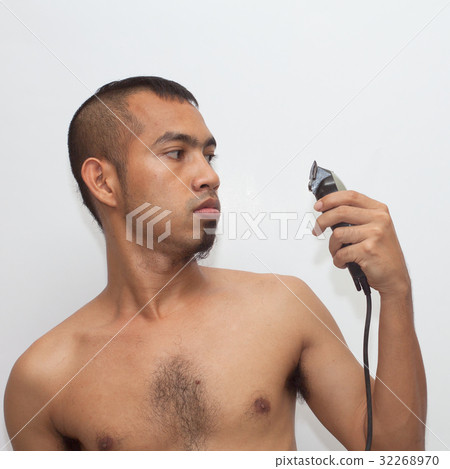 Asian man seriously hold hair clipper 32268970