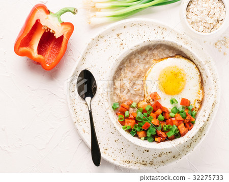 Savory oatmeal, served with vegetables and fried 32275733