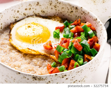Savory oatmeal, served with vegetables and fried 32275734