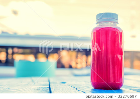 Plastic bottle with red fruit drink in restaurant 32276697