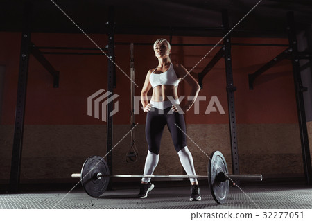 Young fitness girl is standing in the crossfit gym Young fitness girl is standing in the crossfit gym 32277051