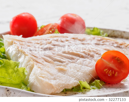 图库照片: close up grilled codfish with basil and cherry